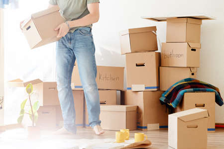 Smiling man hold boxes in new home. Dreaming new homeの写真素材