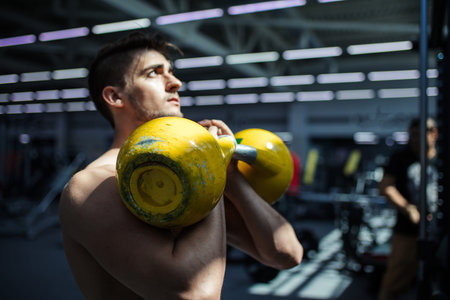 Handsome bodybuilder pumping up muscular body, doing exercises in gym, fitness concept, sport...