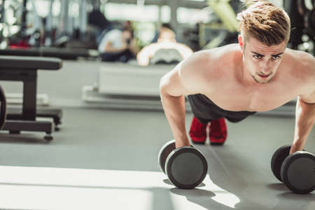Push ups sport, hald-naked fitness man doing push-ups in gym. Male athlete exercising push up during crossfit workout. Sport, Leisure and Healthy lifestyle concept.の写真素材