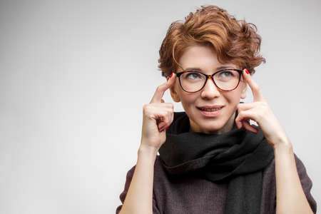 Close up portrait of gorgeous sensual woman with perfect clean skin, wearing short haircut with curly ginger hair smiling at camera keeping lips slightly parted.の写真素材