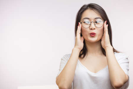 Young Happy Asian woman trying on her new optical spectacles, feeling comfortable and satisfied with spectacle frames and lenses, isolated over white background with copyspace. Vision Conceptの写真素材