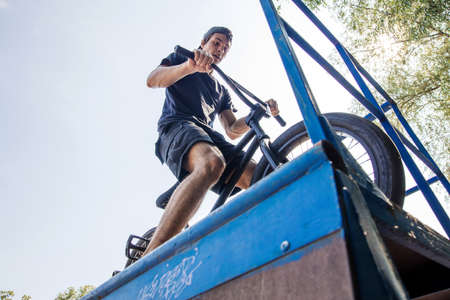 rear back view of Boy riding bmx in a skate park. Beautiful backgroundの写真素材