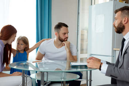 friendly caucasian male psychologist help family going to be divorced, try to eliminate potential psychological problems of child girlの写真素材