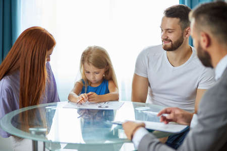 professional psychologist support young married family with daughter, they discuss problems, save family, talk about possible guardianshipの写真素材