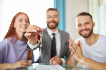 close-up photo of keys, realtor giving key from apartment to owners, new flat, house, real estate services conceptの写真素材