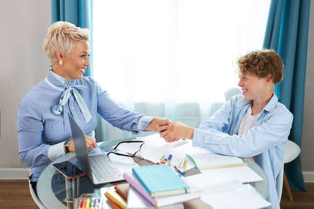 student boy and tutor welcoming each other, going to study. e-learning, at homeの写真素材