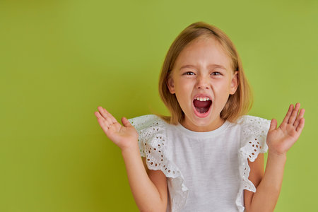 angry little caucasian girl is screaming at camera, shout, emotionally reac on bad news