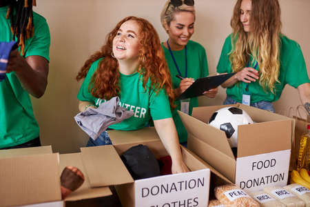 young people collect donation for poor children, they are in charity organization, use cardboard boxesの写真素材