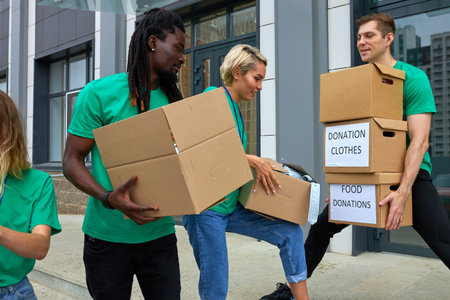 diverse volunteers packing, collecting humanitarian aid in donation box. multi-ethnic group of...