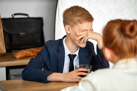 young little boy laugh, close the face, sits with redhead girl at home in living room, wearing...