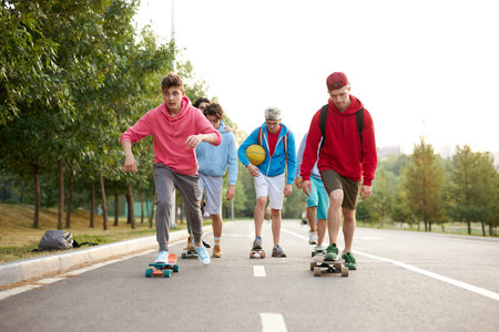 urban teen boys on skateboards,young boys riding in the park on a skateboard. city style. urban...