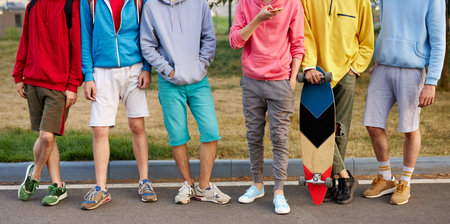 cropped portrait of young generation engaged in skateboarding, caucasian boys in casual wear stand...