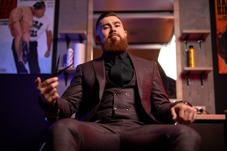 barber scissors, barber shop. brutal man with scissors , stylish bearded man, sitting at his work...