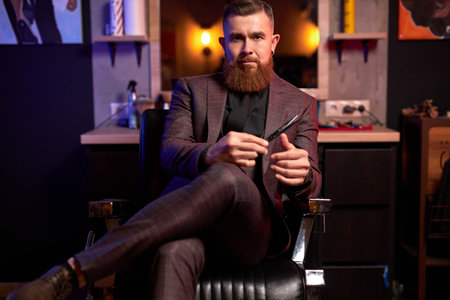 professional hair stylist is ready to cut your hair or beard, male in suit at work place, posing in...