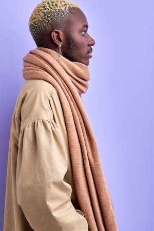 side view on brutal confident african man in trendy wear isolated in studio with purple background, fashionable guy posing, looking away. profile portraitの写真素材