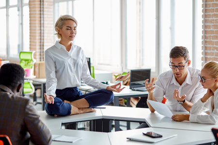 stressed woman at work keep calm, keep balance of mental and psychological health, sits meditating during brainstorm, on tableの写真素材
