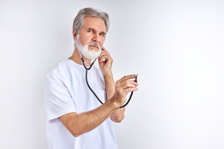 lets listen to your heart beat, old experienced doctor use stethoscope at work, ready to helpの写真素材