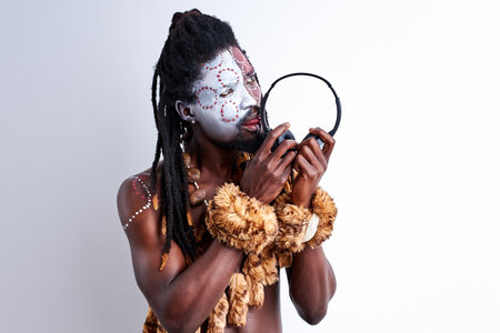 african native man tastes headphones, licks it, use it incorrectly. male in ethnic aborigen wear...