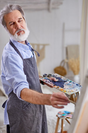 artist painter man painting picture on canvas. happy retirement lifestyle conceptの写真素材