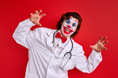 happy doctor mime actor in a white coat and red bow tie using stethoscope, healthcare conceptの写真素材