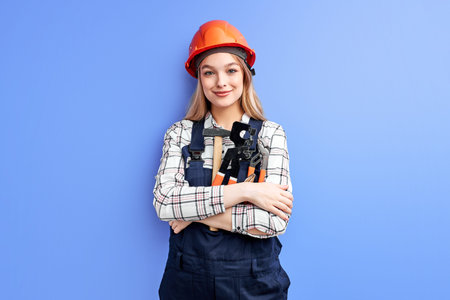 architect business woman in orange helmet standing against blue wall, young caucasian female in...