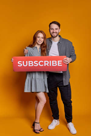 Caucasian Couple Holding Subscribe sign background.の写真素材