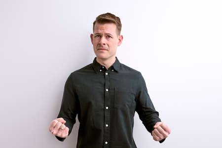 misunderstanding guy gesturing having doubts on whiteの写真素材