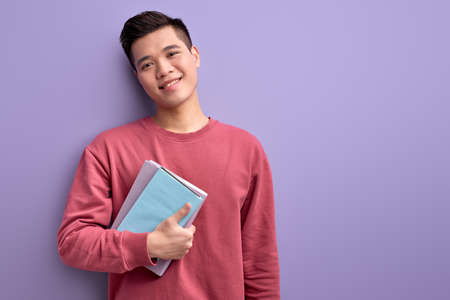 Chinese guy with book in hands enjoy education and university, posingの写真素材