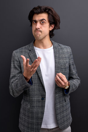 young crazy businessman having angry face, scolding someone isolated on black background