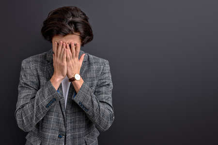 sad male cry, being in stressful situation isolated on black backgroundの写真素材