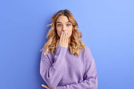 Surprised Female Close Mouth In Shock, Isolated On Blue Backgroundの写真素材