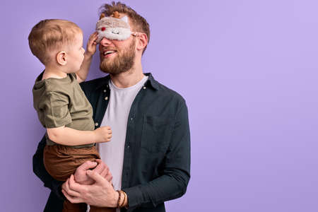 dad in eye mask for sleep doesn t want to take the child to kindergarten in morningの写真素材