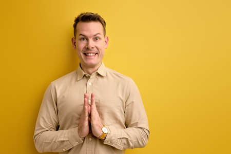 handsome man isolated on yellow background smiling with happy and pleasant expression, waitingの写真素材