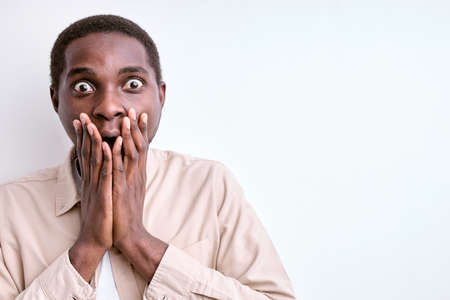 scared black male stand in shock closing face, isolated on white backgroundの写真素材