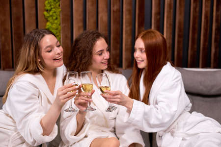Friendly women relaxing in spa and wellness center. Talking and drinking champagne together.の写真素材