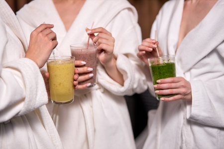 Cleansing the body of toxins, cropped girlfriends in spa salon, wearing bathrobesの写真素材