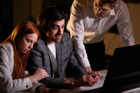 Focused Businessman Working With Sleepy Colleagues In Office At Night. Business Team Working On...