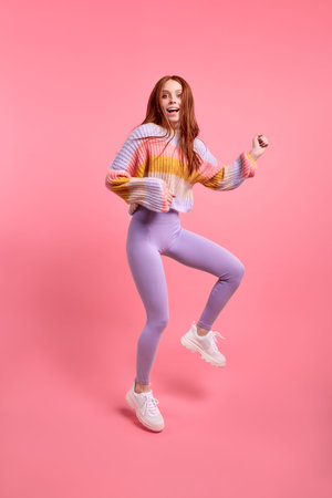 Positive lady jump high celebrate black friday sales shopping center opening, in casual sweater and...
