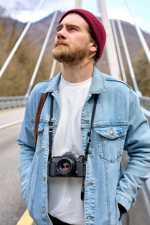 Young Caucasian Male Photographer Travel Alone, Walking With Camera. On Bridge. Portrait of handsome...