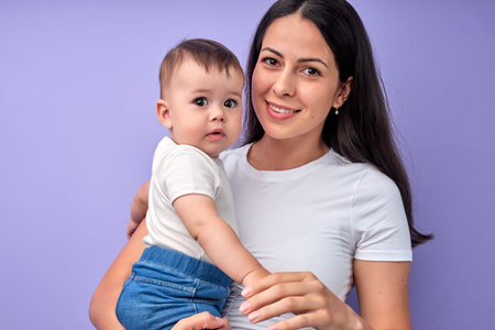 Portrait of beautiful brunette woman with baby child in hands, posing looking at camera, woman with...