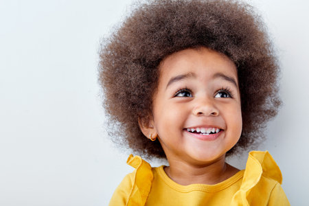 Surprised little afro black girl isolated on white studio background, having fun, copyspace for ad....