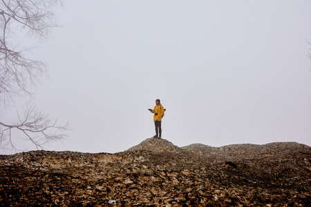 Mountain landscape with rocks and fog. Silhouette of traveler man on cliff. Mystical concept. Side view portrait. Travel, mountains, trip, adventure conceptの写真素材