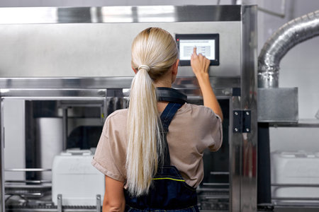 experienced factory worker turn on the robotic line for pesticides bottling and packing. Inspection...