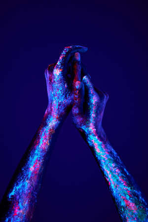 hands with fluorescent body art in neon bold colors. Modern psychedelic creative element with human palm for posters, banners, wallpaper. Copy space for text. Magazine style. Zine culture.の写真素材