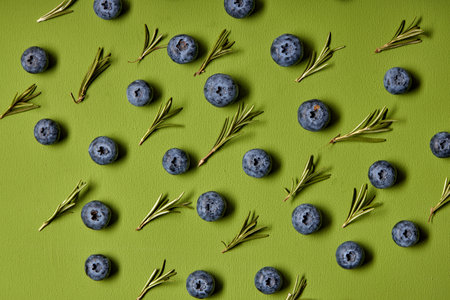 Fresh raw tasty blueberries with leaves isolated on green background, copy space. flat lay. fruits....