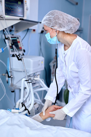 Experienced Caucasian Female Doctor In Medical Robe Checking The Pulse Of Patient Lying On Bed,...