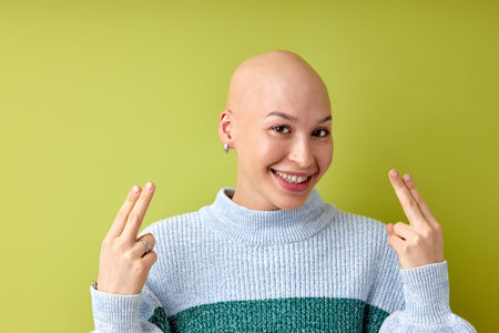 Portrait of positive smiling bald female in casual wear posing looking at camera. Attractive lady with allopecia or cancer enjoy life, having good mood, no reason to feel bad. copy spaceの写真素材