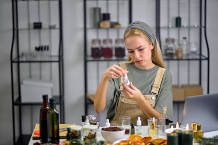 Female going to mix ingredients to make perfume with many bottles of essential oil. sit behind table...
