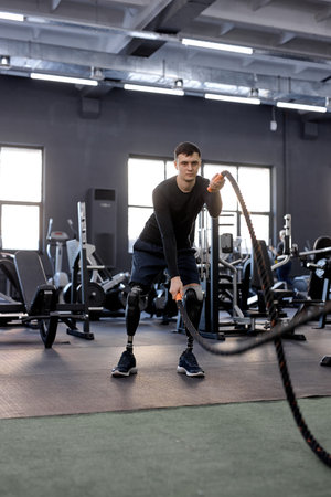 ambitious motivated man making waves with ropes, full length photo. motivation, sportsman focuses on...