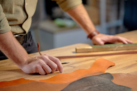 Cropped shot of artisan working with leather in workshop studio, craftsmanship concept, copy space....